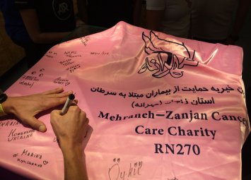 Збір підписів на прапорі іранської благодійної організації по боротьбі з раком
